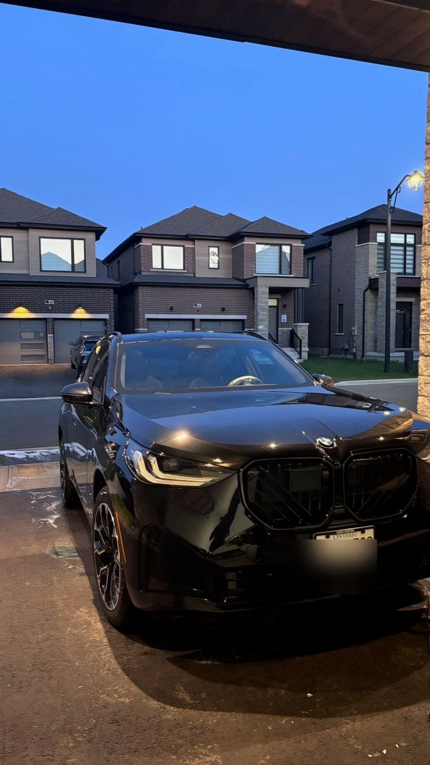 The same black BMW X5 gleaming clean and glossy after detailing at dusk